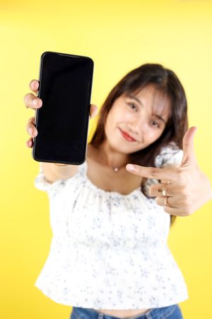 Young Asian Woman Pointing on Blank Screen of Mobile Phone