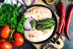 Top view of chicken & vegetables ready for dinner prep on cutting board