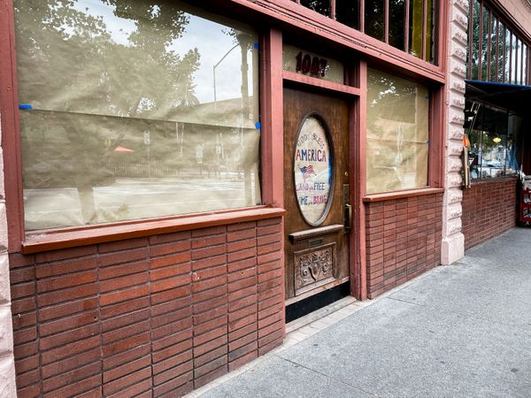 Brown paper covering the windows of restaurant closed for gathering restrictions