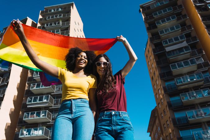 Lesbian couple holding LGBT flag