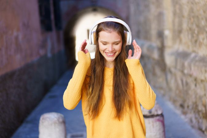 A Joyful Young Woman Enjoying Listening to Music in a Colorful Urban Setting Outdoors