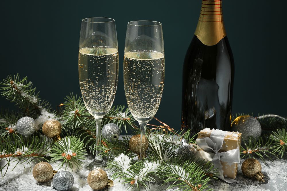 Champagne glasses and bottle on decorated background, close up