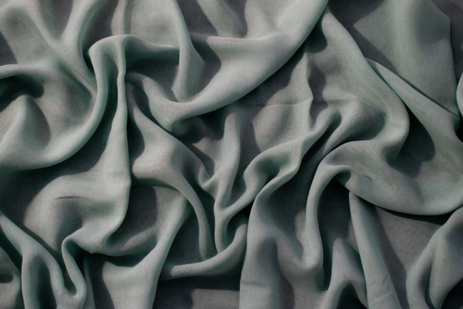 Nude green fabric wavy crumpled background texture with copy space.