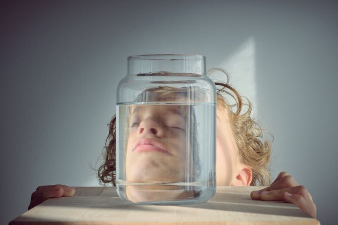 Napping boy near glass jar of water
