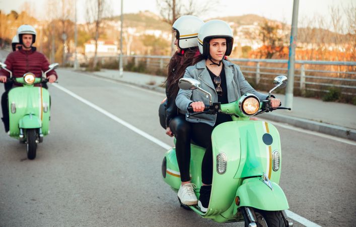 Young people riding motorcycles on city road