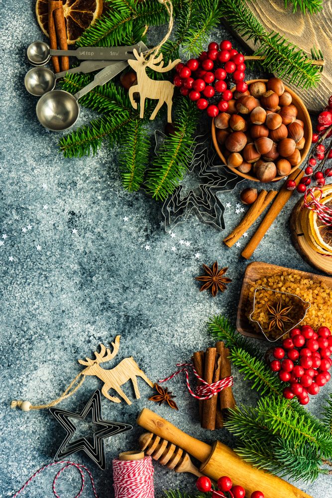 Christmas baking ingredients and cookie cutters on concrete counter with copy space