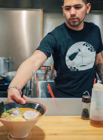 Male serving bowls with soup in restaurant
