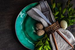 Festive table setting with decorative speckled eggs on teal plate