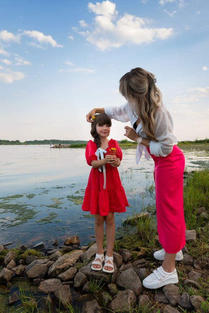 Mom and little daughter walking by the lake or pond