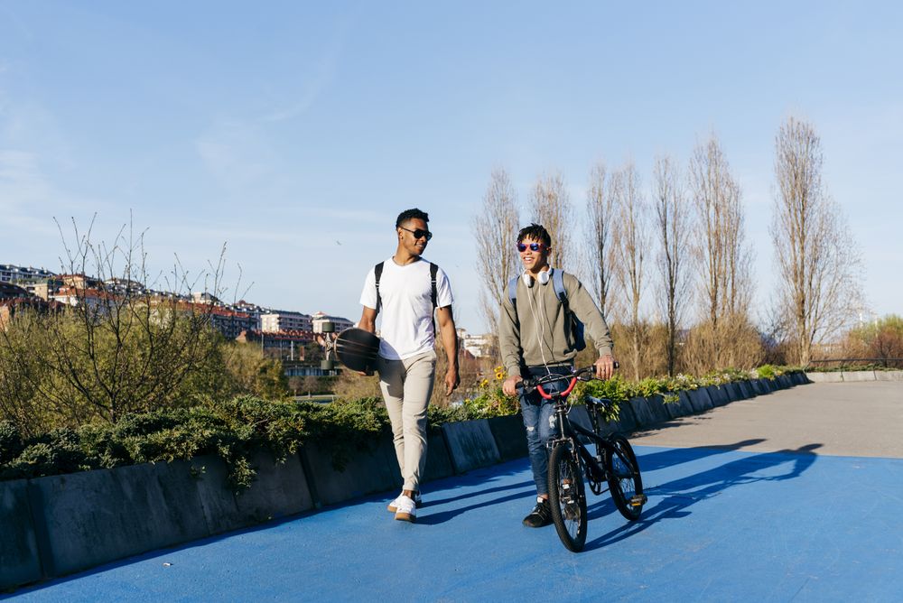 Young Black happy male friends walking in city