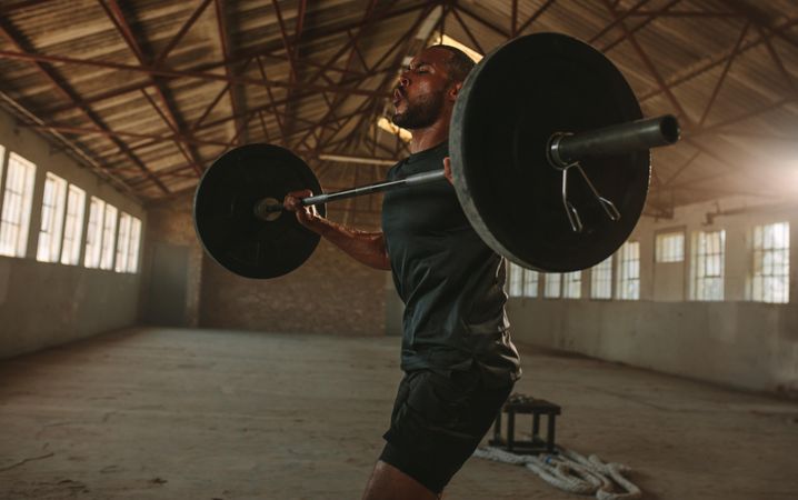 Strong male athlete lifting weights