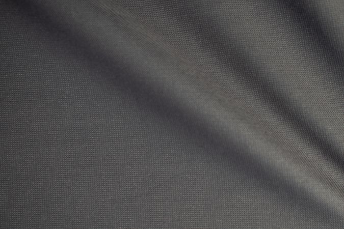 Wavy dark grey fabric background texture. shiny, glossy and elegant background.