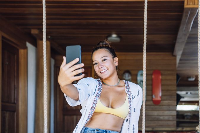 Cheerful woman taking selfie at home