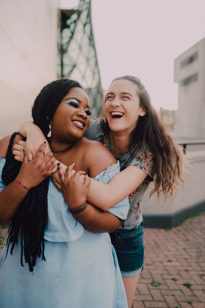 Multiethnic modern women embracing on street