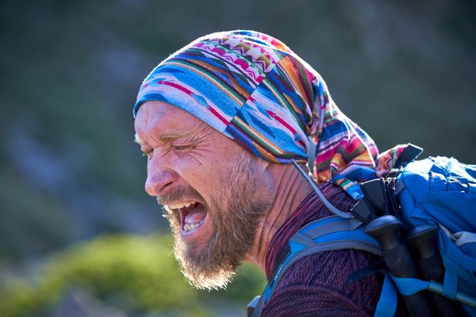 Expressive screaming mature male hiker in kerchief