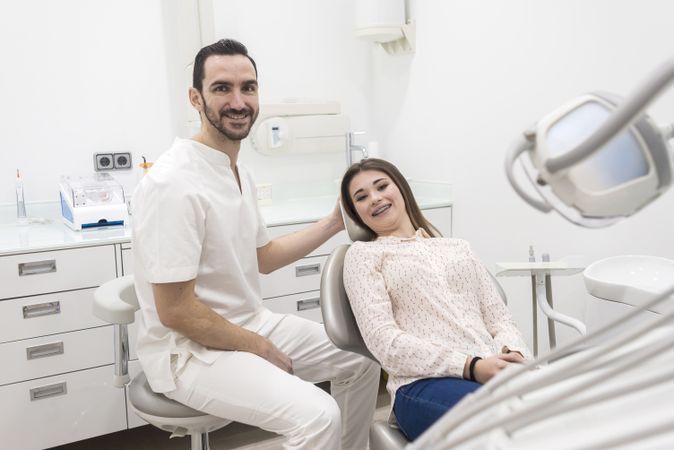 Portrait of a male dentist and young happy female patient