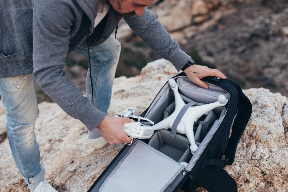 Man unloading backpack with photography equipment