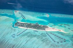 Beautiful tropical island in the Maldives with overwater bungalows and clear water beaches