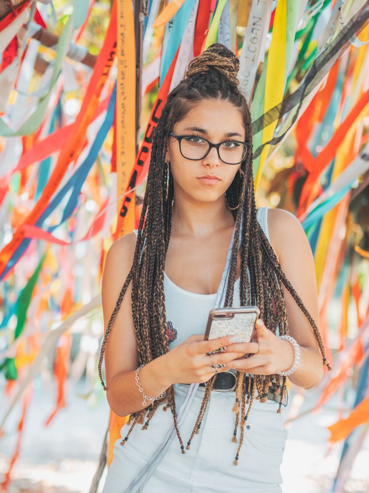 young woman using smartphone outside during festival
