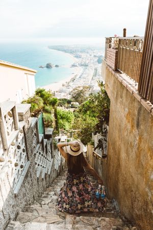Stylish woman picturing coast from stairway