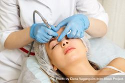 Woman having facial beauty treatment with instrument above her eyebrows 5wvw90