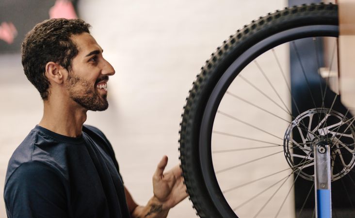 Man aligning a bicycle wheel in a repair shop