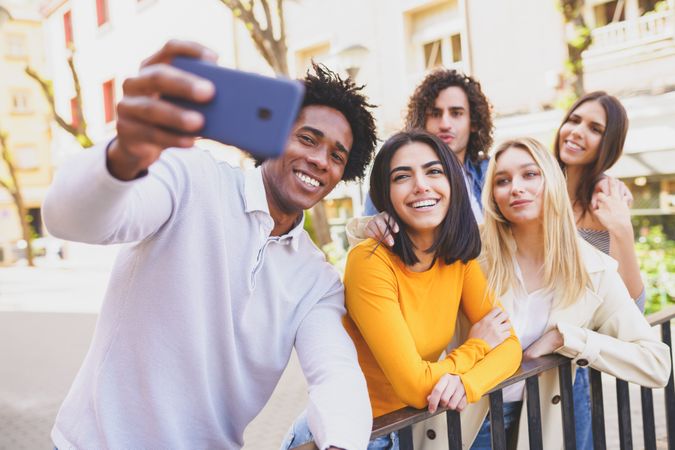 Group of friends taking selfies together outside