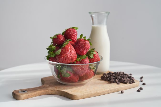 Fresh strawberries and chocolate chips with bottle of milk