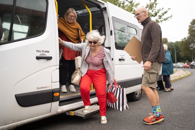 Mature woman exiting bus for art class