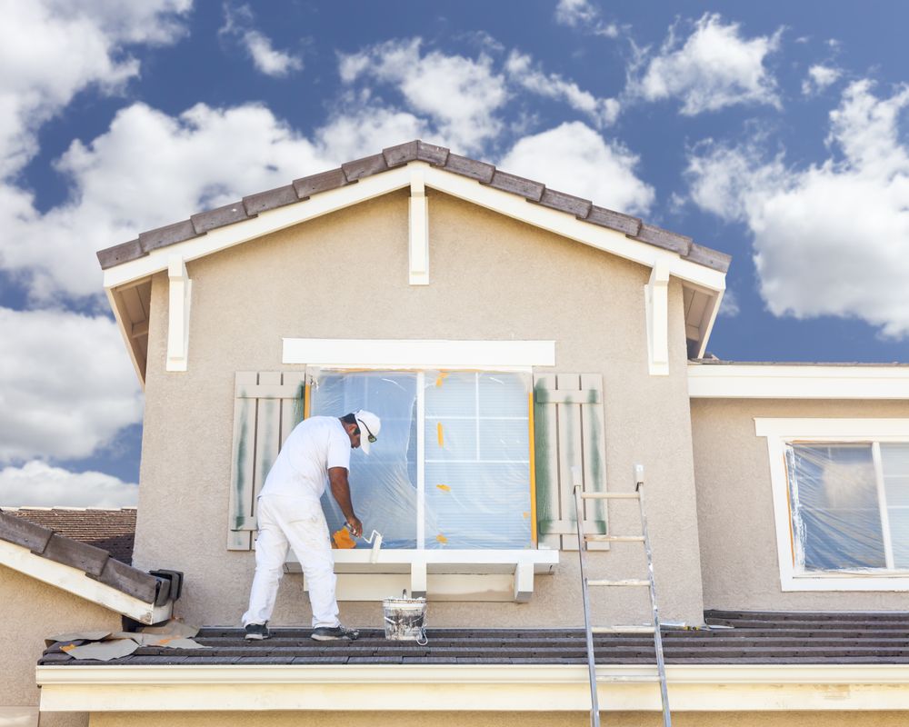 House Painter Painting the Trim And Shutters of Home