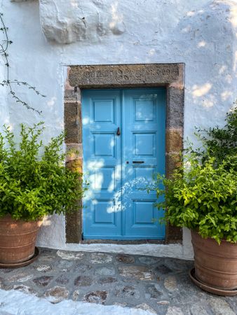 Patmian blue door with potted plants