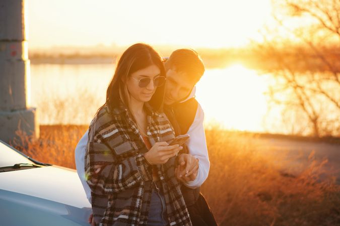 Couple near car use mobile app map