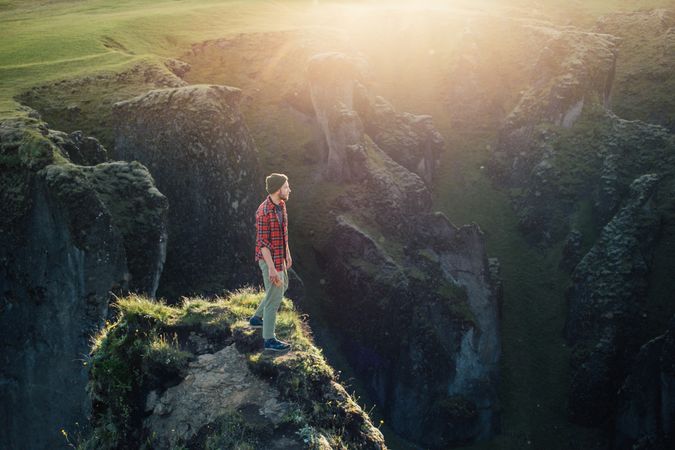Man looking out over on edge of cliff