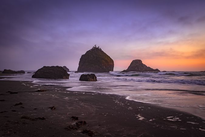 Rocks sitting out from the coast at dusk