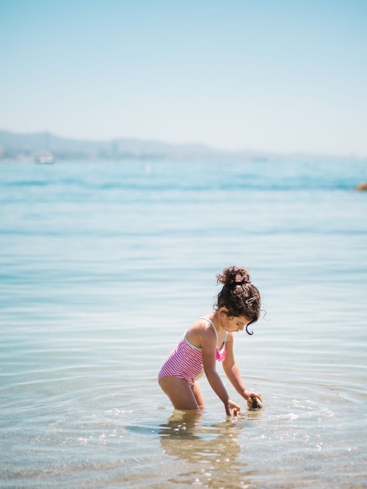 Cute girl playing in water of seaside