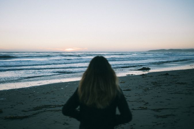 Back of woman walking on beach in California