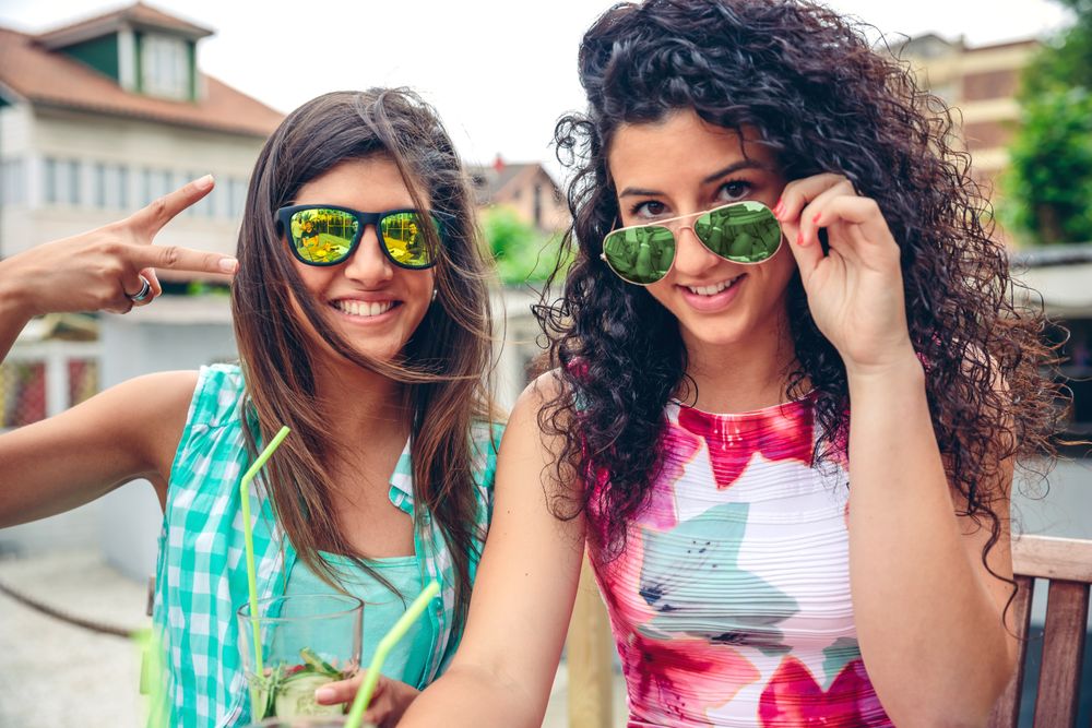 Female friends sitting outside with cocktails