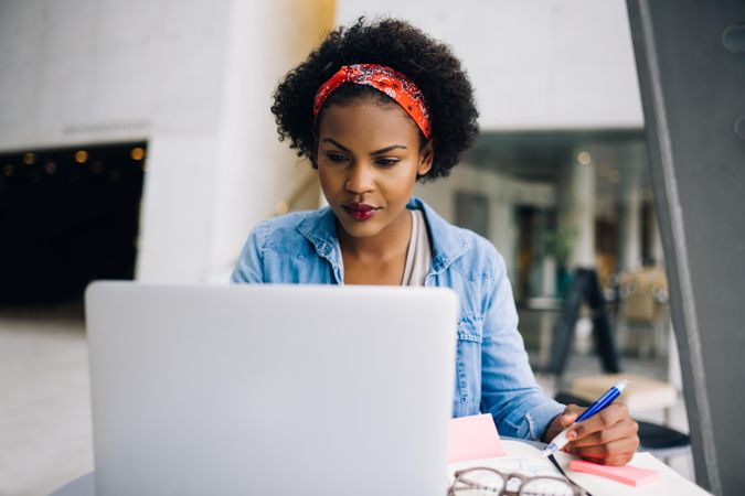 Woman taking notes from computer in open workspace