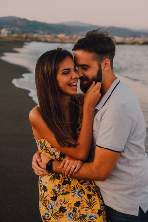 Loving couple embracing happily on sandy beach
