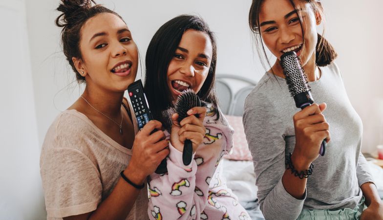 Young women at sleepover having fun singing together