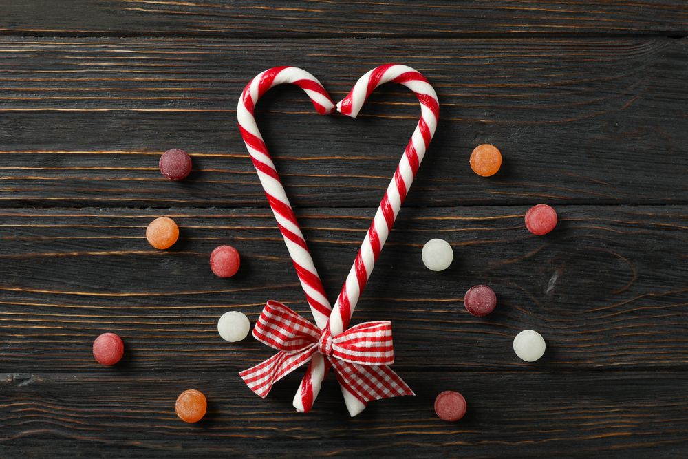 Composition with sweet candies on wooden background, space for text