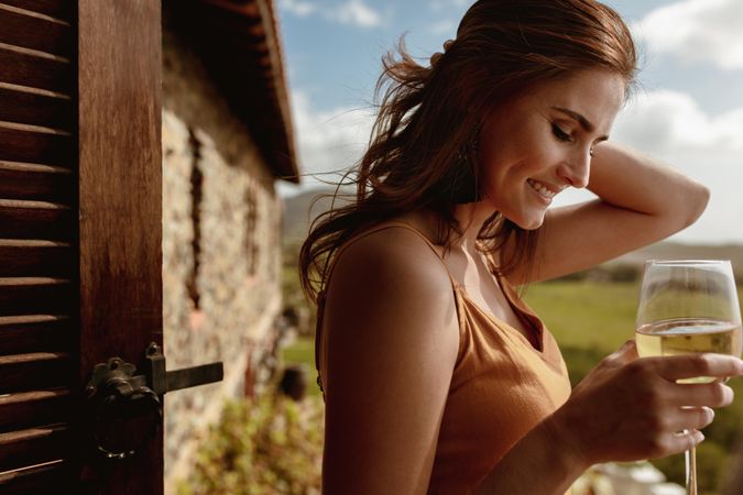 Side view of a woman on vacation in the countryside drinking wine