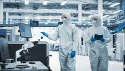 Side view of two people working in hazmat suits