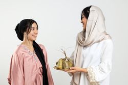 Two Female Sharing Ketupat, Indonesian Rice Cake Popular for Eid Al Fitr