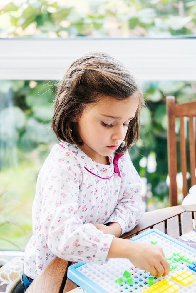 Girl playing with mosaic board game