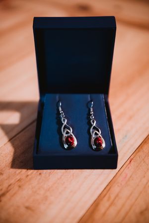 Expensive earrings in box on wood board