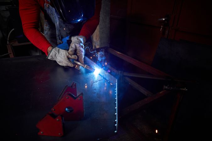 Unrecognizable man making welding seams