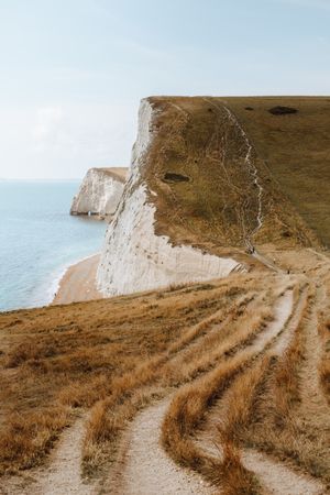 Limestone cliffs with withered grass by water