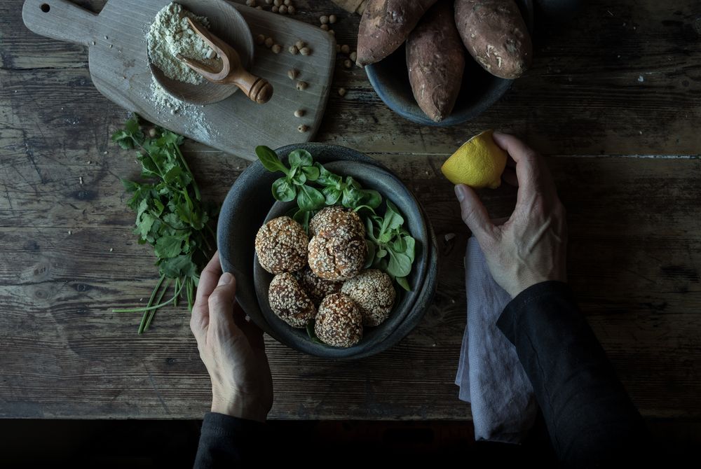 Person rolling in breadcrumbs sweet potatoes