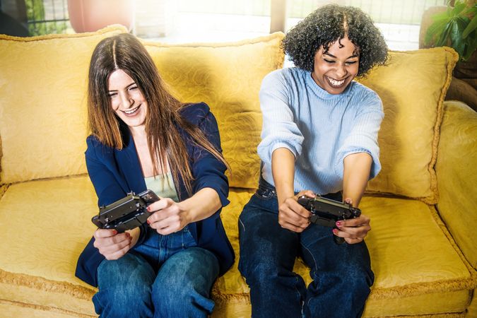 Two female friends playing video game